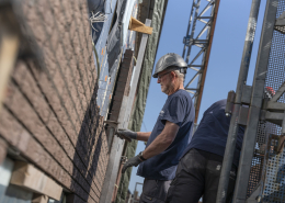 man metselt muur van woning in Appingedam