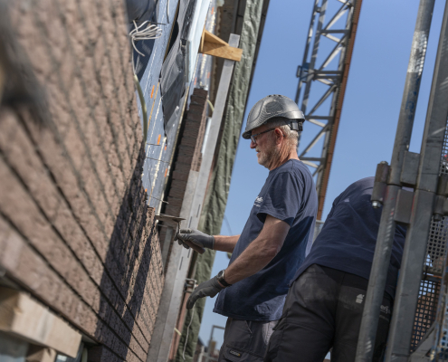 man metselt muur van woning in Appingedam